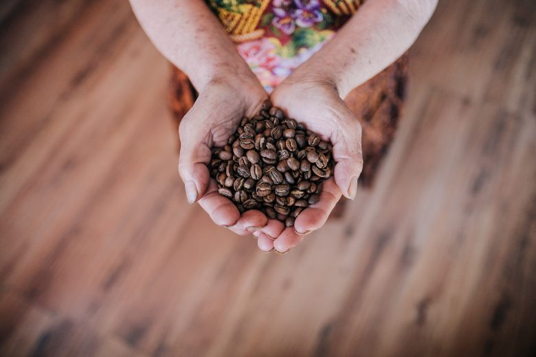 Une paire de mains tenant des grains de café