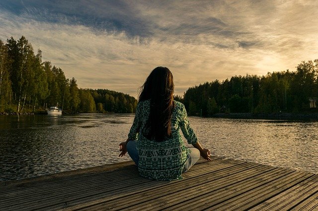 personne sur le bord d'un ponton qui médite